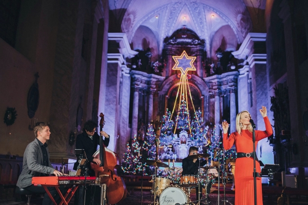 Džezová kapela vystupuje vo veľkolepom, slávnostne vyzdobenom kostole. Speváčka v červených šatách stojí pri mikrofóne, obklopený hudobníkmi hrajúcimi na klávesy, kontrabas a bicie. Za nimi visí nad vianočným stromčekom rozsvietená neónová hviezda, ktorá vytvára vrúcnu a radostnú atmosféru.