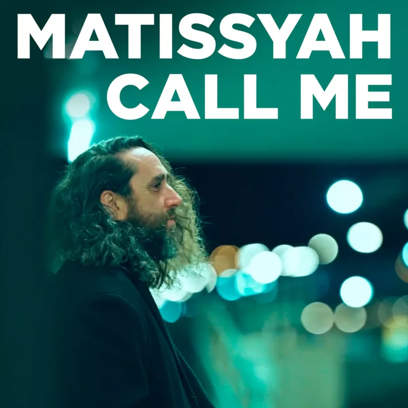 Muž s dlhými kučeravými vlasmi a bradou stojí z profilu pod mestskými svetlami. Vyššie uvedený text znie "Matissyah Call Me." Scéna pôsobí kontemplatívnym dojmom.