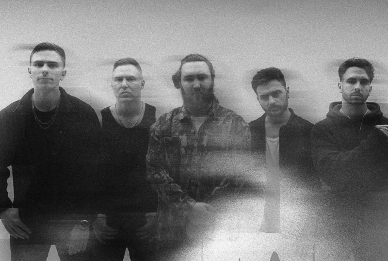 Čiernobiela fotografia päťčlennej kapely, mierne rozmazaná. Členovia pôsobia kontemplatívne a dodávajú skupine umelecký, éterický nádych.