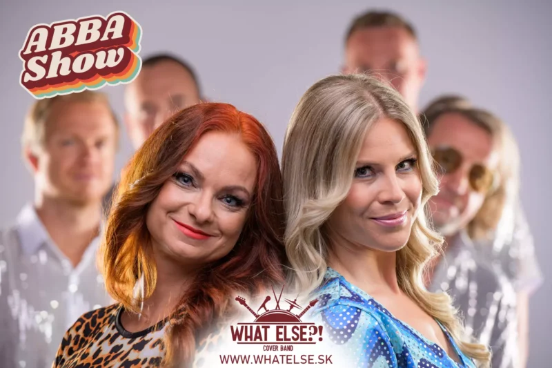 Dve ženy v retro oblečení sa usmievajú do kamery, na rozmazanom pozadí sú štyria muži. Žiariva a radostná téma pocty skupine ABBA s nápisom „ABBA Show“.