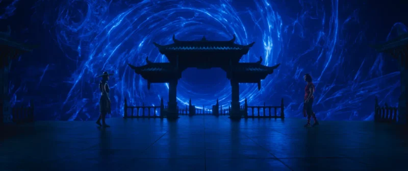 Dve postavy stoja oproti sebe v mystickom prostredí s víriacim modrým vírom a siluetou tradičnej pagody. Scéna pôsobí napäto a nadpozemsky.