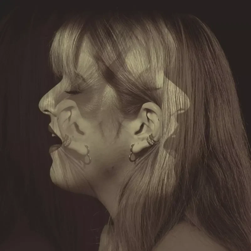 Dvojexpozícia ženského profilu v sépiových tónoch, zobrazujúca jej tvár v smiechu aj v zamyslení, vyvolávajúca emócie radosti a introspekcie.