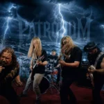 Heavymetalová kapela vystupuje na pódiu energicky, s intenzívnymi výrazmi a dynamickými postojmi. Blesky a vlny dramaticky narážajú do búrlivého pozadia, čím umocňujú intenzívnu a silnú atmosféru.