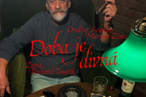 Obal albumu „Doba je divná“: bradatý starší muž fajčí v tmavej stoličke pri zelenej lampe; fotografie a drink na stole, náladový tón.