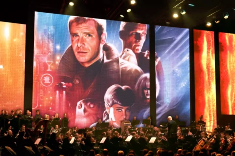 Živý orchester vystupuje pod obrovskými obrazovkami, na ktorých sa uprostred červených a modrých svetiel javiska premietajú dramatické postavy sci-fi filmov vrátane vesmírneho kapitána.
