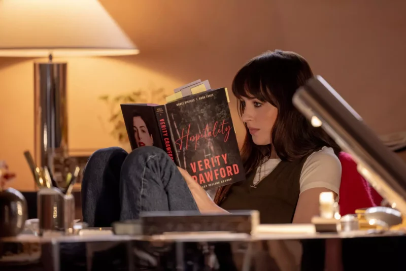 Woman reads Colleen Hoover’s “Verity” in a warmly lit room, creating a cozy, quiet, contemplative mood.