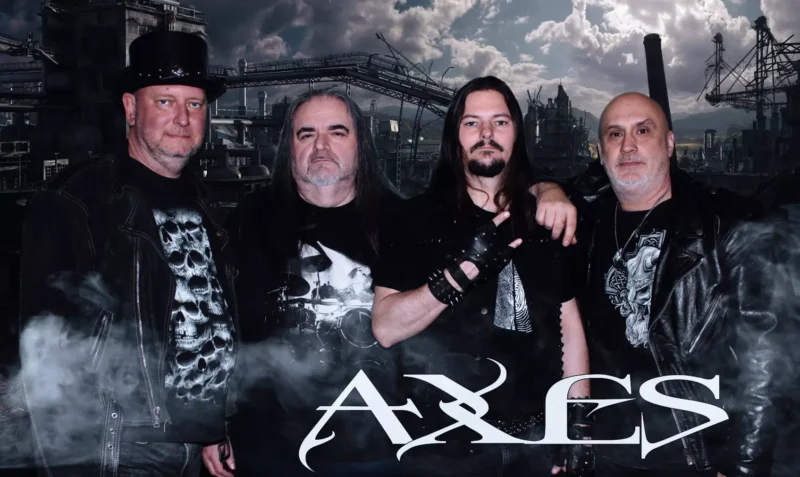 Štyria muži v čiernom rockovom oblečení pózujú pred priemyselnou panorámou zahalenou do dymu; táto atmosférická fotografia metalovej kapely nesie v spodnej časti logo „AXLES“.