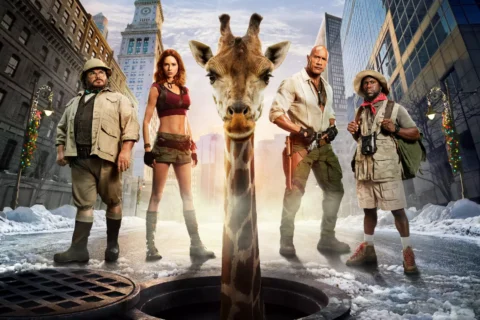 Zo šachty uprostred zasneženej mestskej ulice sa vynára žirafa, obklopená štyrmi drsnými dobrodruhmi; táto surreálna scéna pôsobí humorne a filmovo.